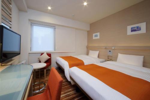 东京赤坂京王布莱索酒店的酒店客房设有两张床和一台平面电视。