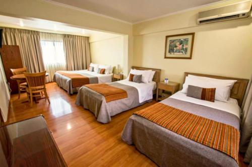 圣地亚哥HOTEL DACARLO的酒店客房设有两张床和一张桌子。