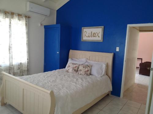 圣玛丽1 Queen Bedroom At Csompó Empire的一间卧室拥有蓝色的墙壁,配有一张带枕头的床。
