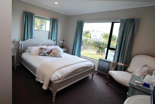 惠灵顿太平洋美景住宿加早餐旅馆的一间卧室设有一张床、一个窗口和一把椅子