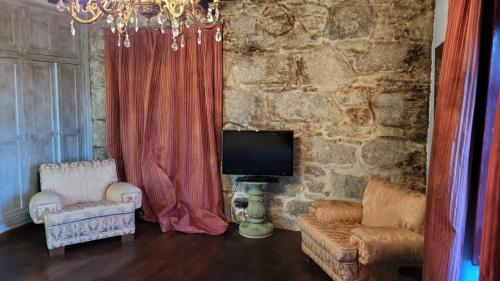 VillasanteCasa Rural del General Albelda的客厅配有电视、沙发和椅子