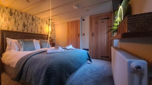 安布尔塞德Fox Corner, Ambleside, romantic retreat for two, dog friendly, hot tub的一间卧室配有一张带蓝色棉被的床