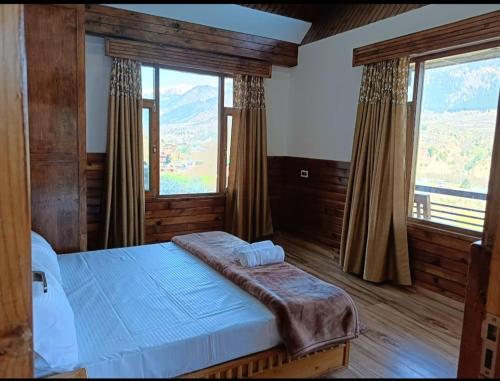 ShirirCrazy House Devku's Villa的一间卧室设有一张床和两个大窗户