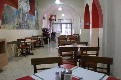 普埃布拉Hotel Casa de Oración San José的一个带桌椅的用餐室和一个拱门
