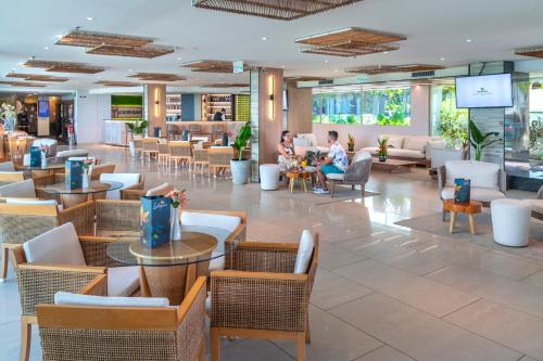 纳塔尔Serhs Natal Grand Hotel & Resort的一个带桌椅的餐厅的大堂