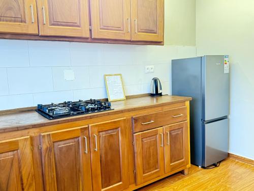 BueaAkhard Haus的厨房配有木制橱柜和不锈钢冰箱。