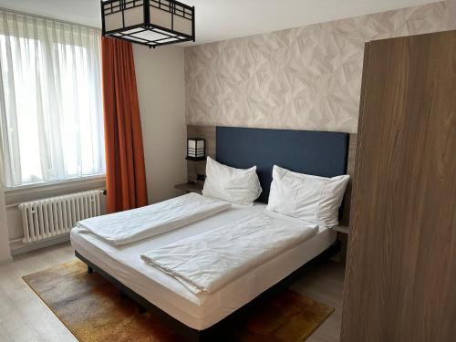 卢塞恩斯帕茨酒店的一间卧室配有一张带白色床单的大床