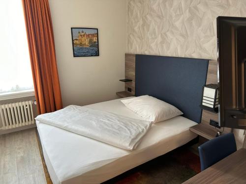 卢塞恩斯帕茨酒店的卧室配有白色的床和电视。