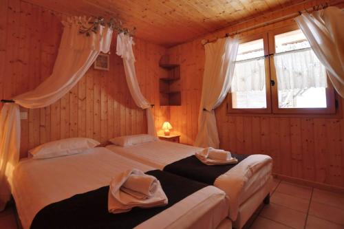 蒙特里永Chalet Les Grolets - Ardent的一间卧室设有两张床和两个窗户。