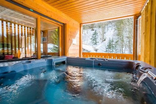 蒙特里永Chalet Les Grolets - Ardent的一个带窗户的木屋内的热水浴缸