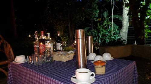 阿鲁沙Kizumba House的一张桌子,上面有紫色的桌布,上面有瓶子和杯子