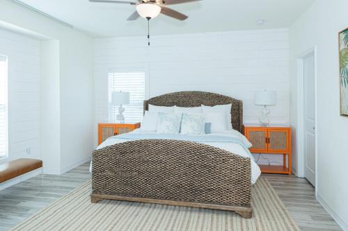 彭萨科拉New Listing, Luxury 4bd Steps to Beach Club的一间卧室配有柳条床和吊扇