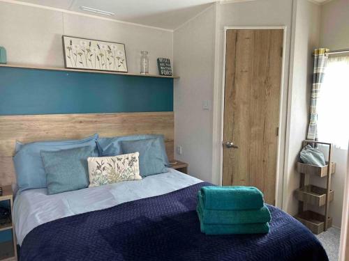 佩恩顿Hoburne Devon Bay - Hot Tub 2 Bed Paignton的一间卧室配有蓝色的床和蓝色床头板