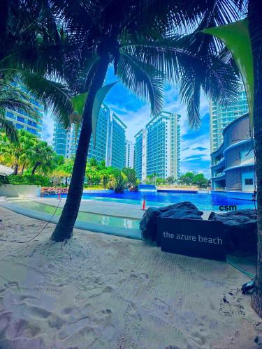 马尼拉Staycation in the Corner by MJJ的棕榈树海滩和海滩旁的标志