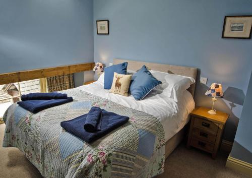 肯德尔Spring Cottage的蓝色卧室,配有蓝色枕头的床