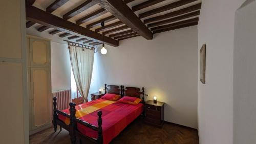 古比奥Borgo Antico的一间卧室配有一张红色床罩的床