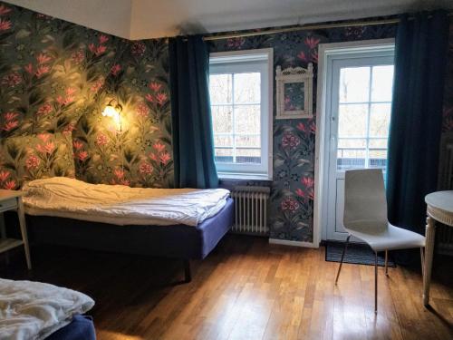 KvidingeVilla Signedal Hostel的一间卧室设有一张床和两个窗户。