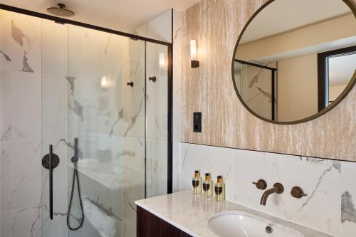 巴黎Maison Cassandre的带淋浴、盥洗盆和镜子的浴室