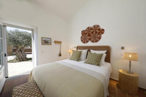 维拉诺瓦德卡塞拉Quinta Baltazar Casa particular的一间卧室设有一张大床和一个窗户。