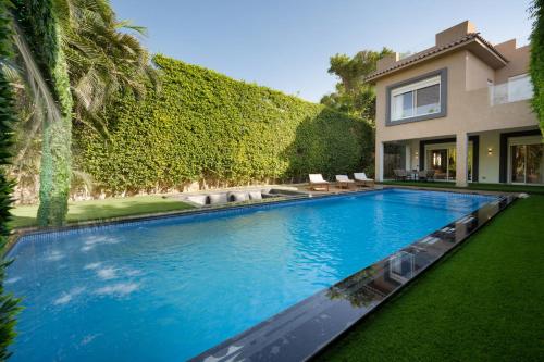 开罗Zyra villa with pool and waterfall in New Cairo的一座房子后院的游泳池