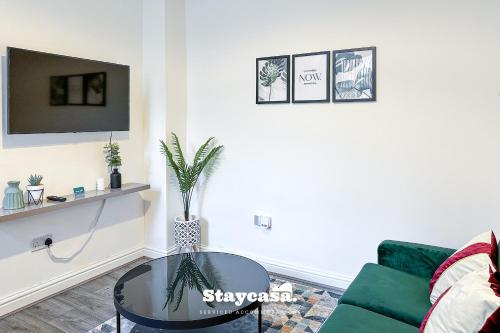 曼彻斯特Stylish Ensuite Room - Superfast Wi-fi 250mbps的客厅配有绿色沙发和玻璃桌