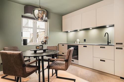 卑尔根Bryggen // Fløyen Apartments的厨房配有桌椅和水槽。