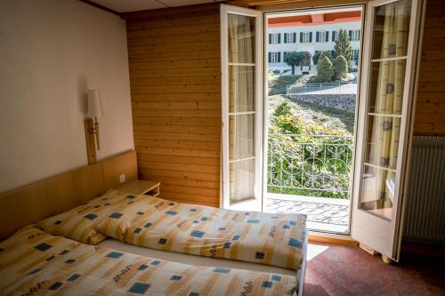克恩斯Hotel Alpenhof的一间卧室设有一张床和一个开放式门