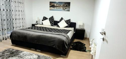 林茨3-Zimmer- Wohnung in Traun, nähe Linz und Wels的一间卧室配有一张带黑色床单和枕头的床。