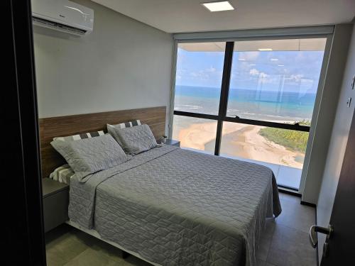 累西腓Flat #2506 BARRA HOME STAY的一间卧室配有一张床,享有海滩美景