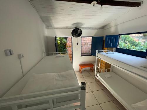 伊塔卡雷Ooxe Hostel的一间设有两张床和天花板上的闹钟的房间