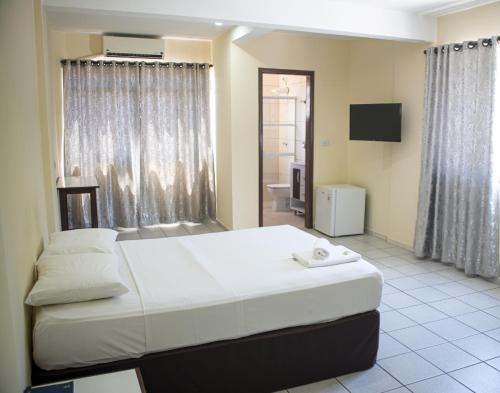 伊瓜苏Smart Cataratas Hotel的一间带大床的卧室和一间浴室