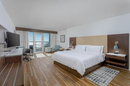 彭萨科拉海滩彭萨科拉海滩智选假日酒店的酒店客房配有一张床、一张书桌和一台电视。