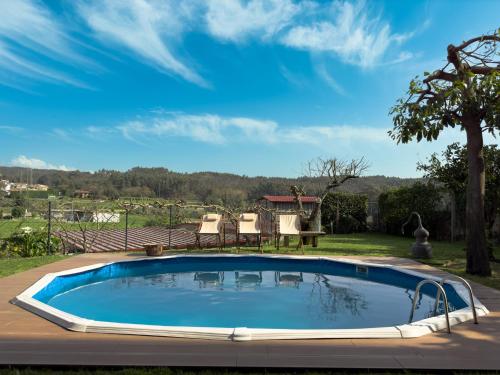 Paço de SousaOlival House的庭院内的游泳池,配有桌椅