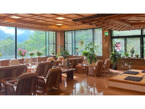松本Nakanoyu Onsen Ryokan - Vacation STAY 07485v的餐厅设有桌椅和窗户。