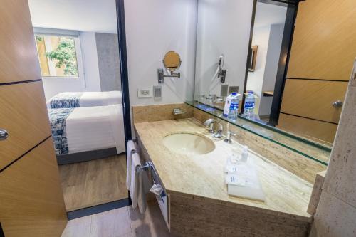 佩雷拉阿巴迪亚广场GHL酒店的一间带水槽和大镜子的浴室