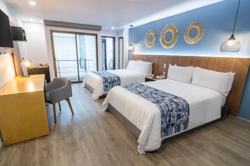 佩雷拉阿巴迪亚广场GHL酒店的酒店客房配有两张床和一张书桌