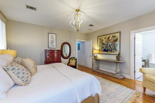 圣罗莎海滩Grove By The Sea: Passin' Thru的卧室配有白色的床和吊灯。