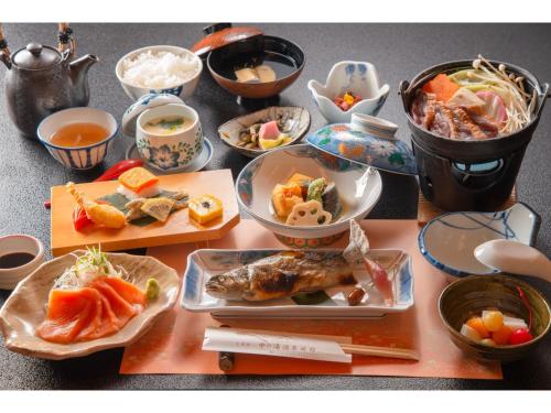 松本Nakanoyu Onsen Ryokan - Vacation STAY 06683v的餐桌,盘子上放着食物和碗