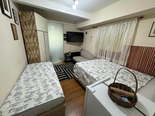 圣保罗Hostel Tia Ana的小房间设有两张床和电视