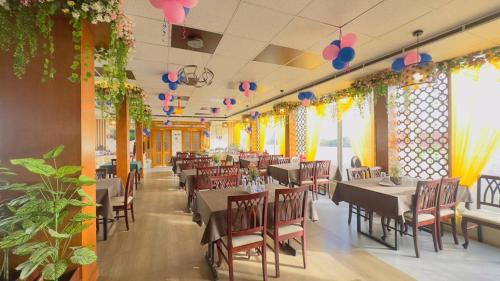 达卡Hotel Grand Circle Inn Dhaka的一间带桌椅和鲜花的用餐室