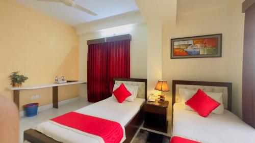 达卡Hotel Grand Circle Inn Dhaka的两张位于酒店客房的床铺,配有红色枕头