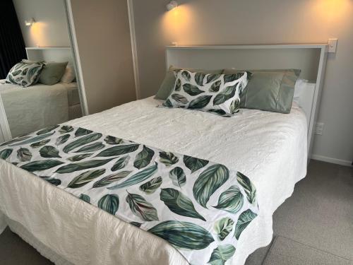 罗托鲁瓦Rotorua Central Hosted B&B的一张带绿色和白色毯子及枕头的床