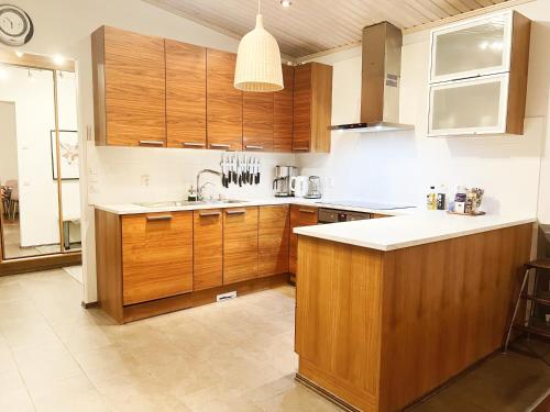 罗瓦涅米Nordic Villa with private sledding hill的一个带木制橱柜和水槽的大厨房