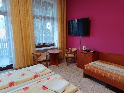 隆代克-兹德鲁伊Dom Wczasowy Magnolia的酒店客房设有两张床和一台平面电视。
