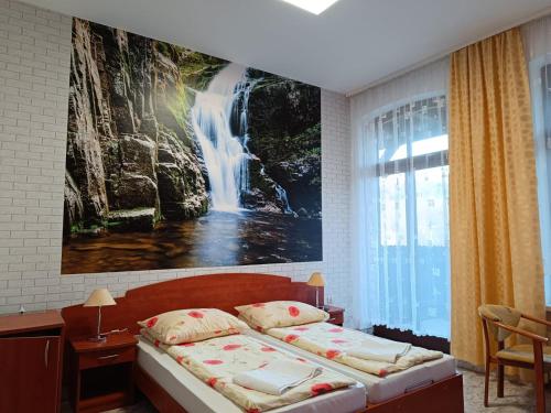隆代克-兹德鲁伊Dom Wczasowy Magnolia的卧室的墙上挂有瀑布画