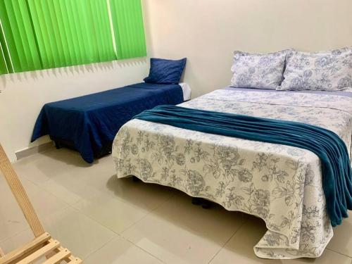 巴西利亚Melhor valor de Brasília próximo ao Aeroporto e Plano的一间卧室配有两张带蓝白色床单的床