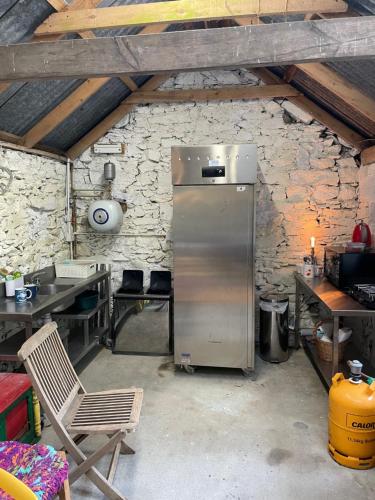 Dún ArdGlamping at The Old Rectory的厨房配有石墙内的冰箱