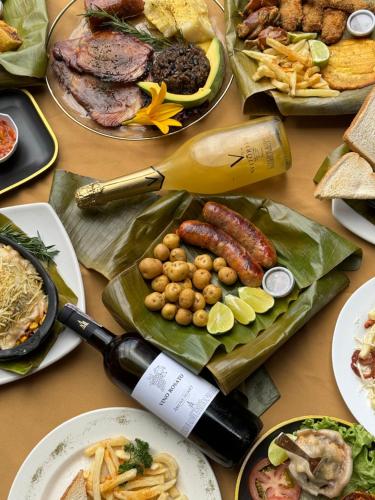 拉卡莱拉Glamping termales La Calera的餐桌,带食物盘和一瓶葡萄酒