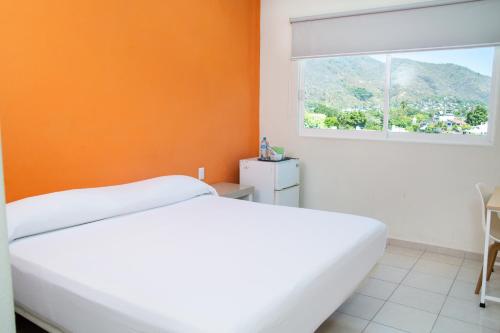 锡瓦塔塔内霍Fabuloso Hotel Las Vegas的卧室配有白色的床和橙色的墙壁
