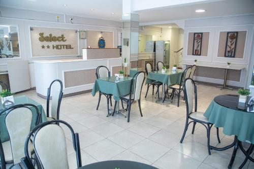 马德普拉塔精选酒店的一间带绿色桌椅和柜台的餐厅